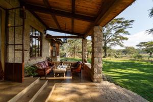 a porch of a house with a couch and a table at Yellow House 3-bedroom Villa In Nature in Naivasha