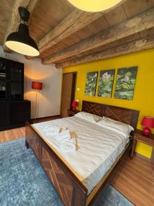a large bed in a room with a yellow wall at RaBi Rooms - Rafting & Bike Rooms in Valbrenta 