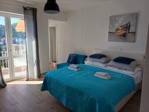 a bedroom with a bed with blue sheets and a window at Meridiens in Dubrovnik
