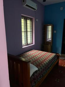 a blue bedroom with a bed and two windows at Tharissu potta farm stay in Kollengode