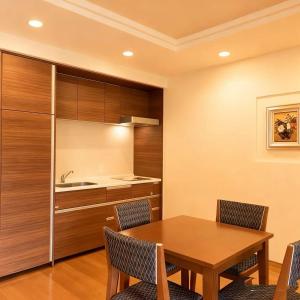a kitchen with a wooden table and chairs at Wyndham Garden Nagaizumi in Numazu