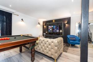 a living room with a pool table and a couch at Slough Fun Home with Hot tub, Cine, Garden & Parking in Colnbrook