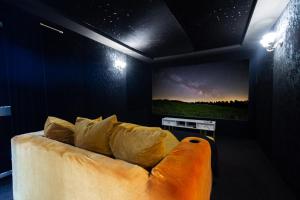 a living room with a couch and a television at Slough Fun Home with Hot tub, Cine, Garden & Parking in Colnbrook
