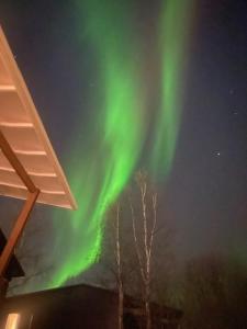 an image of the northern lights in the sky at Lapland Riverside Home in Rovaniemi +13 photos