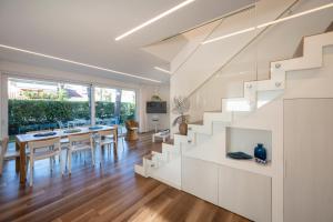 a kitchen and dining room with white walls and stairs at Summer Villas in Lignano Sabbiadoro