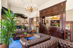 a lobby with leather couches and a table at Hotel Diament Plaza Gliwice in Gliwice