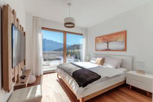 a bedroom with a bed and a large window at Laax Alpine Lodge by Quokka 360 - terrace with magnificent mountain views in Laax
