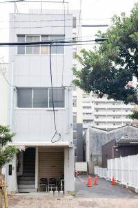 a white building with tables and chairs in front of it at Darin博多 in Fukuoka