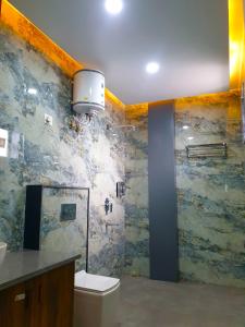 リシケーシュにあるHotel Savaya Luxury Stay Near AIIMS Rishikeshの石壁のバスルーム(トイレ付)