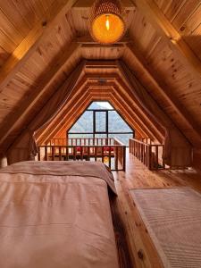 een slaapkamer in een blokhut met een groot raam bij Foresta Suit Bungalov in Ardeşen