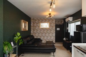 a living room with a couch and a brick wall at Darin博多 in Fukuoka