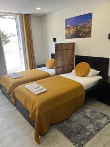 two beds sitting next to each other in a room at Almada Downtown 104 in Porto