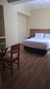 een slaapkamer met een bed, een tafel en een stoel bij MOON Edificio in San Vicente de Cañete