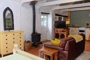 a living room with a couch and a stove at Cottage Sleeps 2- Parking Wood Fire Garden Pets in Lizard