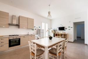 a kitchen with a table and chairs in a room at Mirèa - Lux Coastal Villa in Torre Lapillo +22 photos