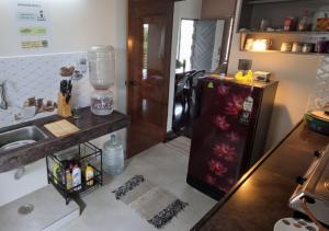 a kitchen with a small refrigerator and a sink at The Sparrow in Kanyakumari +15 photos