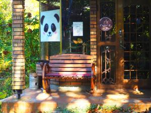 a bench in front of a door with a panda sign at Snowfall Meteor 飛雪流星 in Kaminoyama