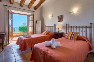 Dos camas en una habitación con balcón. en Finca Penya Redona, en Alquería Blanca 53 fotos más