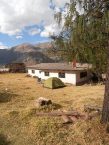 a tent in a field in front of a house at Nilo Trek House in Chiquián