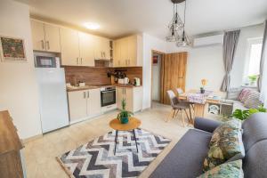 a living room with a couch and a kitchen at ARKSIS Apartman in Sárvár