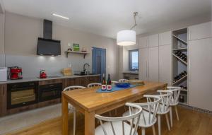 eine Küche mit einem Holztisch und weißen Stühlen in der Unterkunft Villa Castel Muschio by Villas Guide in Omišalj