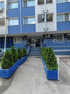 a blue building with bushes in front of it at N9 Studentski Loft in Sofia