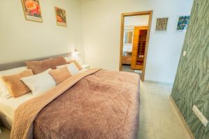 a bedroom with a large bed with pillows at ARKSIS Apartman in Sárvár