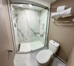 a bathroom with a shower and a white toilet at Red Roof Inn Forrest City in Forrest City
