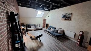 a living room with a couch and a brick wall at Halte détente chez Sylvie près A71 Bourges - chambres avec sauna, billard, salle ciné in Civray +12 photos