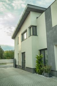 a white building with windows and a courtyard at ARKSIS Apartman in Sárvár
