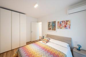 a bedroom with a bed with a colorful blanket on it at Summer Villas in Lignano Sabbiadoro