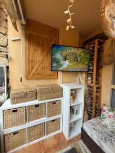 a room with a tv hanging on a wall with baskets at Residencial Bajo con jardín y jacuzzi privado Calahonda Royale in Cabopino
