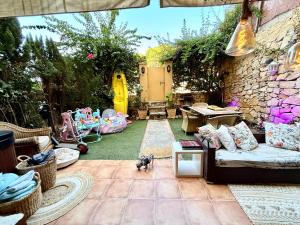 a patio with a couch and a dog in a yard at Residencial Bajo con jardín y jacuzzi privado Calahonda Royale in Cabopino