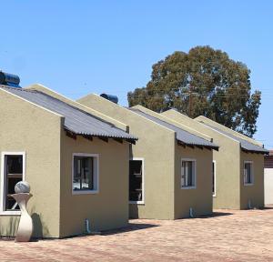 a row of buildings with a vase in front of them at Pereng Lodge in Ga-Moloi