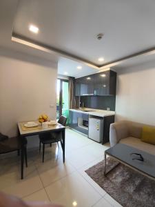 Una cocina y una sala de estar con un sofá y una mesa. en Apartment in Pattaya beach , chon buri, en Pattaya South
