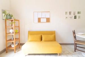 a yellow bed in a room with a table at La Maison Castello in Abbiategrasso +23 photos