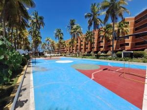 ein Resort mit Basketballplatz und Palmen in der Unterkunft Apartamento vacacional Tucacas in Tucacas