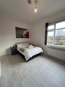 a white bedroom with a bed and a large window at TianTian in Birmingham