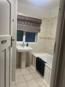 a bathroom with a sink and a tub and a sink and a toilet at 4 BRD House, with Double Parking in Earley +34 photos