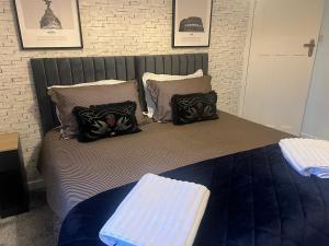 a bed with pillows on it in a bedroom at 4 BRD House, with Double Parking in Earley