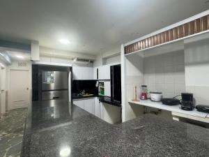 eine große Küche mit weißen Schränken und einer Theke in der Unterkunft Apartamento vacacional Tucacas in Tucacas