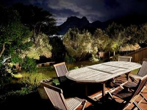 a wooden table and chairs in a yard at Nudist Naturist Port Nature Sandy Bay in Cape Town