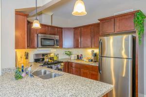 Una cocina con gabinetes de madera y un refrigerador de acero inoxidable. en Westcott 1BR & Loft Apt in Mansion mins SU & JMA Dome, en Syracuse