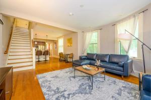 Una sala de estar con un sofá azul y una mesa. en Westcott 1BR & Loft Apt in Mansion mins SU & JMA Dome, en Syracuse