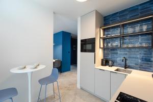 a kitchen with a sink and a table with chairs at Resort Apartamenty Klifowa Rewal 84 in Rewal