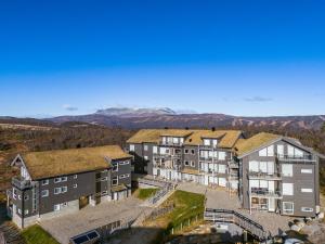 ヤイロにあるKikut Panorama Geilo Ski-in Ski-outの山を背景にした建物の航空写真