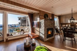 ヤイロにあるKikut Panorama Geilo Ski-in Ski-outの石造りの暖炉とテーブル付きのリビングルーム