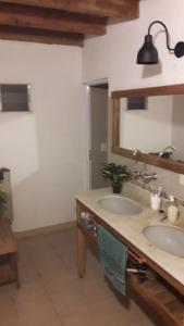a bathroom with two sinks and a mirror at El tobogan in General Madariaga