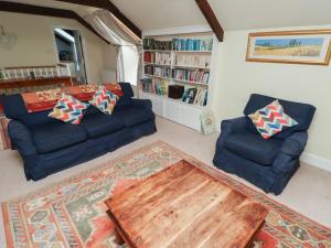 IngramにあるHoneymugのリビングルーム(青いソファ2台、木製テーブル付)