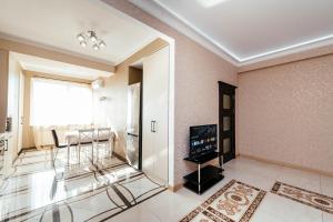 un soggiorno con televisione e una sala da pranzo di Apartment ultra center Sky House a Chişinău